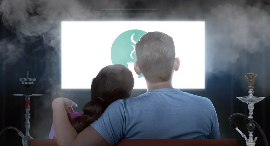 View from behind of two people watching TV on a sofa with a hookah on both sides