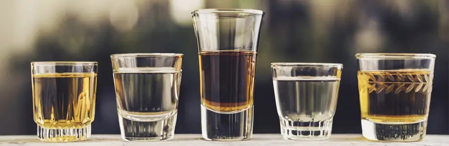 Variety of shot glasses filled with different types of alcohol