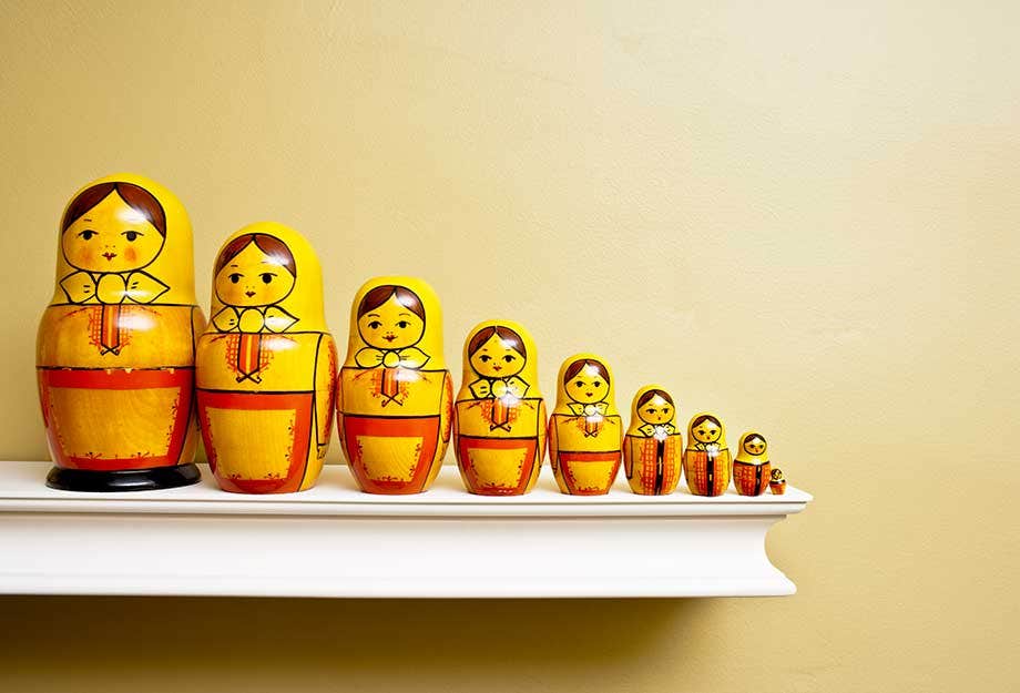 A set of nesting dolls on a shelf lined up from largest to smallest