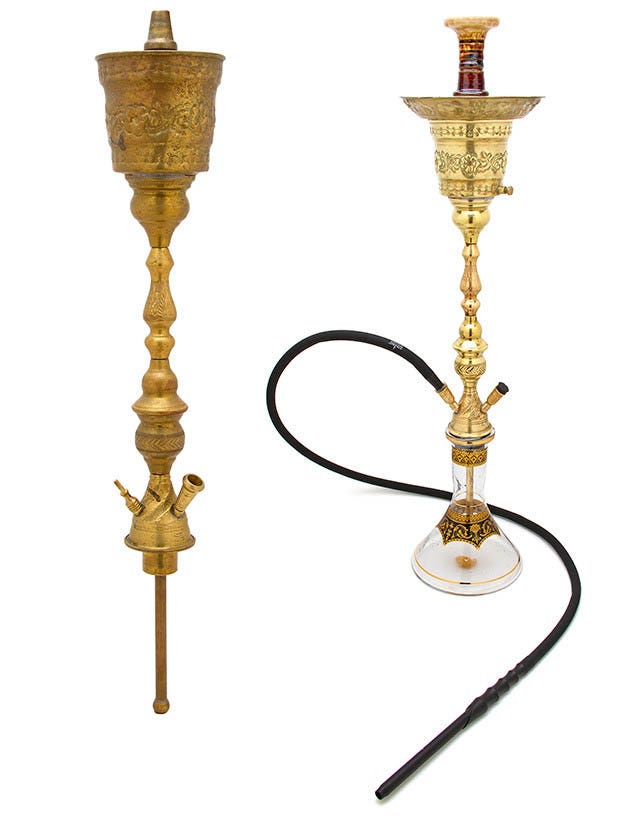 An old hookah or shisha pipe with a brass bowl on a window-cill